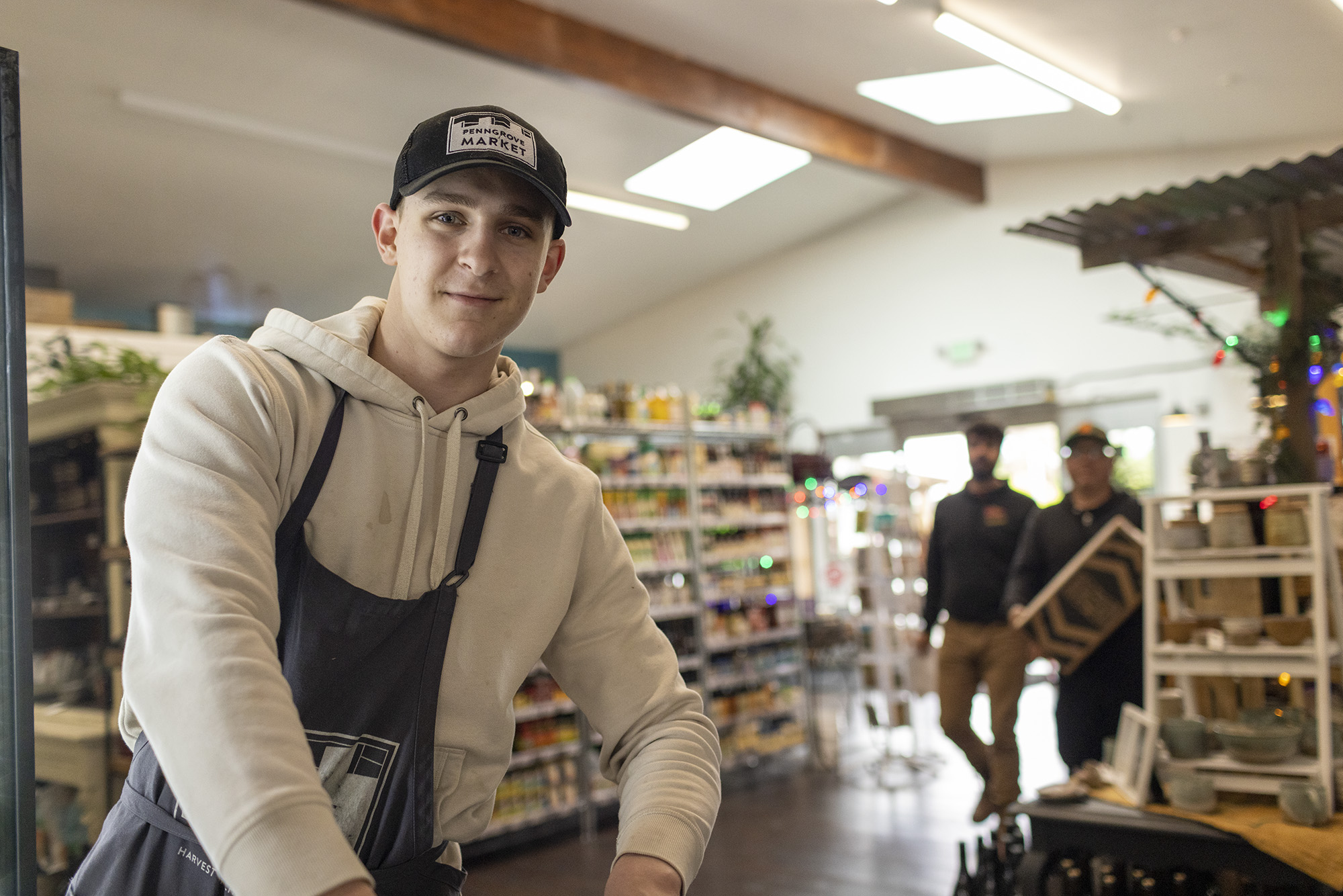 Penngrove Market employee smiling for camera while restocking groceries.
