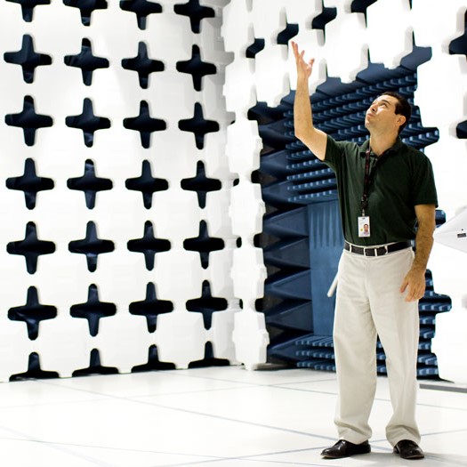 Keysight Technologies. Employee pointing and looking up in research lab.