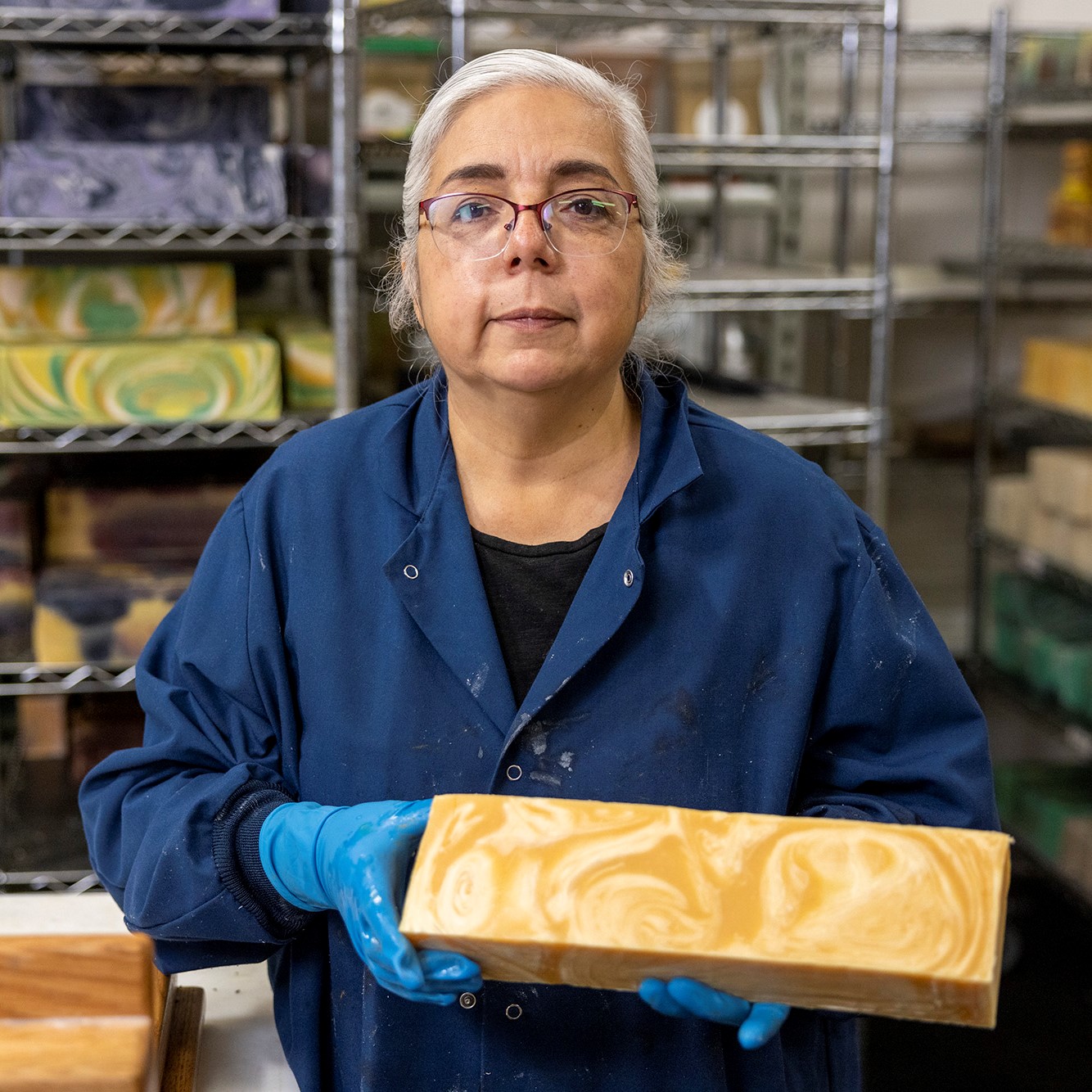 Owner and founder of Soap Cauldron, Emma Mann, holding up large block of soap